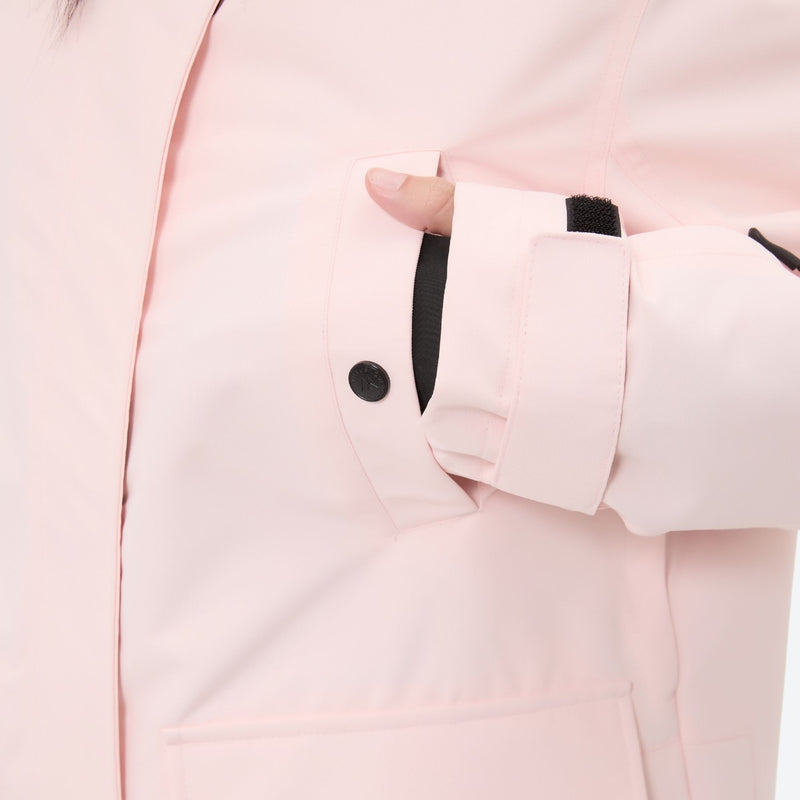Women's 2-layer insulated ski suit - light pink, side pocket snap close-up with hand, for cold-weather winter sports