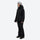 Women's waterproof 3L ski jacket and pants set - black jacket with black pants, on-model side view, for snowy mountain travel