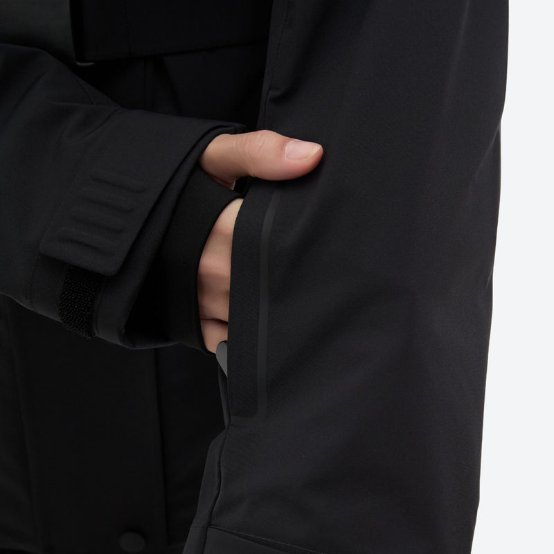 Women's waterproof 3L ski jacket and pants set - black, cuff close-up with hand, for snowy mountain travel