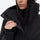 Women's belted snow jacket with suspender pants - black, collar close-up with hand, for cold-weather winter sports