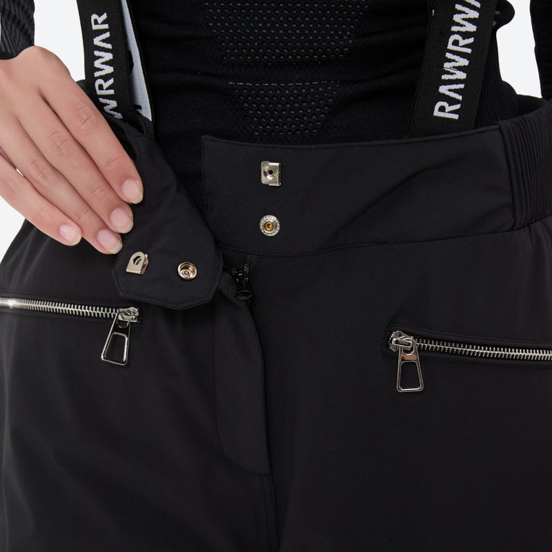 Women's breathable striped ski jacket with bibs - black, waistband snap close-up with hand, for resort and backcountry days