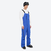 
                  
                    Men's waterproof 3L bib snow pants - blue bib snow pants with white top, on-model side view, for powder and piste riding
                  
                