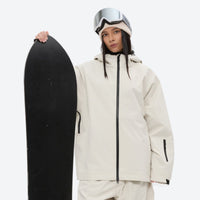 
                  
                    Women's 2-layer snowboard jacket and pants - cream, on-model front with upright snowboard, for powder days and winter commute
                  
                