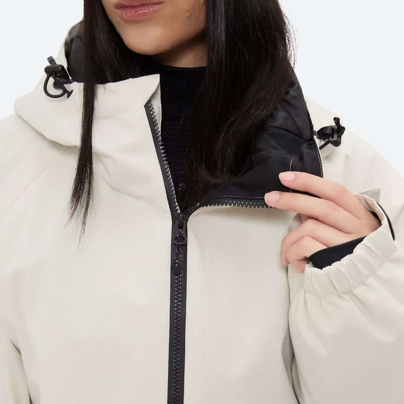 Women's minimalist breathable ski jacket set - cream, collar close-up with hand, for powder days and winter commute
