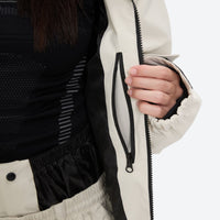 
                  
                    Women's minimalist breathable ski jacket set - cream, interior zip pocket close-up with hand, for cold-weather winter sports
                  
                