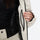 Women's minimalist breathable ski jacket set - cream, interior zip pocket close-up with hand, for cold-weather winter sports