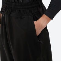 
                  
                    Men's minimalist breathable ski jacket set - black snow pants, side pocket close-up with hand, for resort and street wear
                  
                