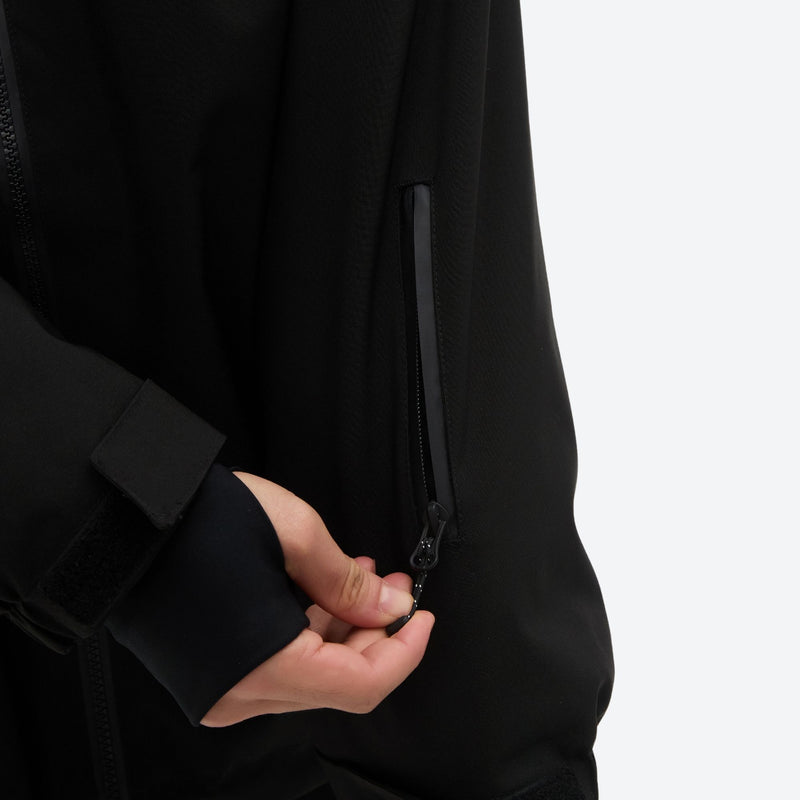 Men's 2-layer snowboard jacket and pants - black, chest zip close-up with hand, for resort and street wear