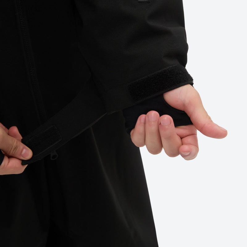 Men's waterproof 2L snow jacket and pants - black, cuff strap close-up with hand, for powder days and winter commute