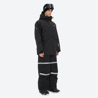 
                  
                    Unisex snowboard bib pants - black jacket with black bib pants, on-model side view, for cold-weather winter sports
                  
                