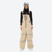 
                  
                    Women's reflective trim ski jacket with suspender bibs - tan bib pants, for powder days and winter commute
                  
                