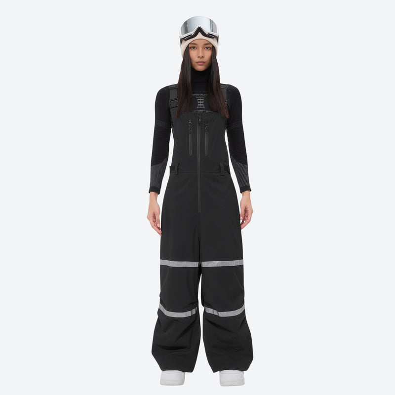 Women's reflective trim ski jacket with suspender bibs - black bib pants, on-model front view, for resort and street wear