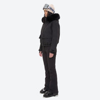
                  
                    Women's waterproof 3L ski jacket and bib pants series - black fur trim hood jacket with black bib pants, on-model side view
                  
                