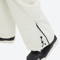 
                  
                    Breathable ski jacket with quilted lining - white snow pants, hem close-up over shoe detail, for resort and backcountry days
                  
                