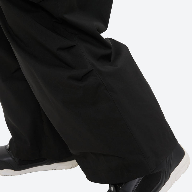Men's breathable half-zip ski pullover set - black snow pants, hem over shoe close-up detail, for cold-weather winter sports