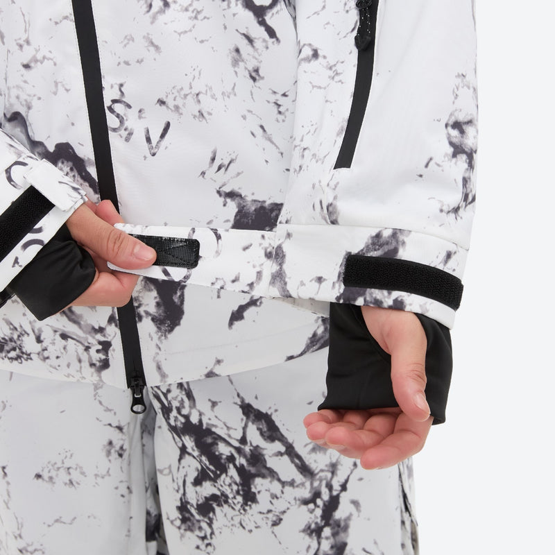 Unisex printed snowboard jacket and bibs - white marble print, cuff close-up with hand, adjustable detachable suspenders