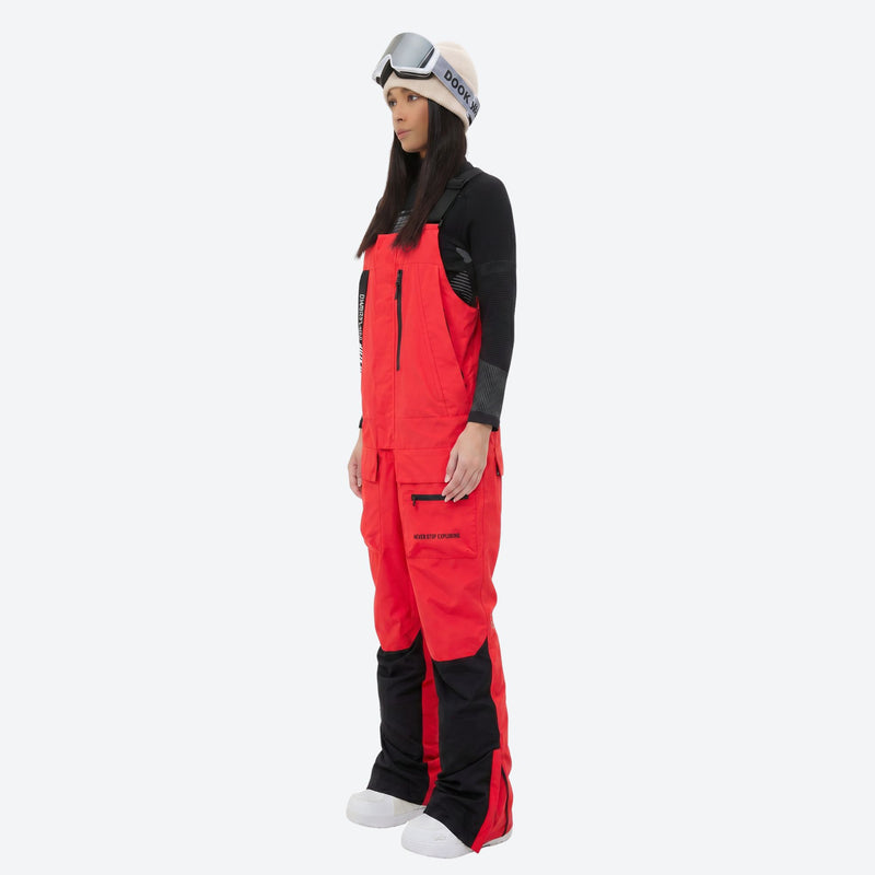 Women's waterproof 3L bib snow pants - red bib snow pants with black top, on-model side view, for cold-weather winter sports