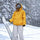 Men's breathable ski jacket and pants set - amber orange, on-model front with upright snowboard, for skiing and snowboarding