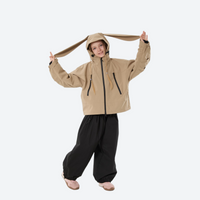 
                  
                    Youth 3-layer ski suit with bib pants - tan jacket with black pants, for family resort ski days
                  
                