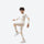 Kids compression base layer suit - cream kids compression base layer suit, leg-raise pose view, for layering under ski wear