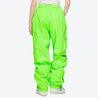 
                  
                    Men's breathable ski jacket with cargo pants - neon green snow pants, on-model back view, for resort and street wear
                  
                