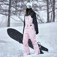 
                  
                    Unisex snowboard bib pants with snow gaiters - pink bib pants with black top, for resort and backcountry days
                  
                