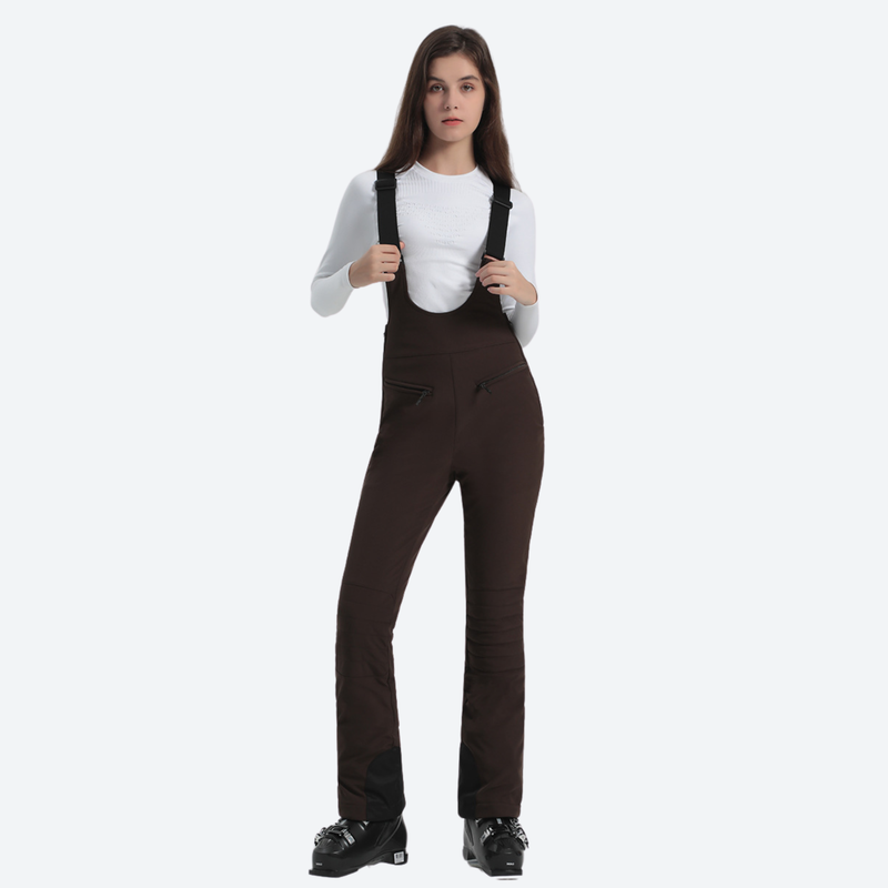 Women's slim ski bib with inner snow skirt - brown slim fit ski bib, front view with hand at chest, for snow sports weekends