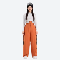 
                  
                    Women's colorblock waterproof snow jacket and pants - orange wide-leg snow pants with white top, for powder and piste riding
                  
                