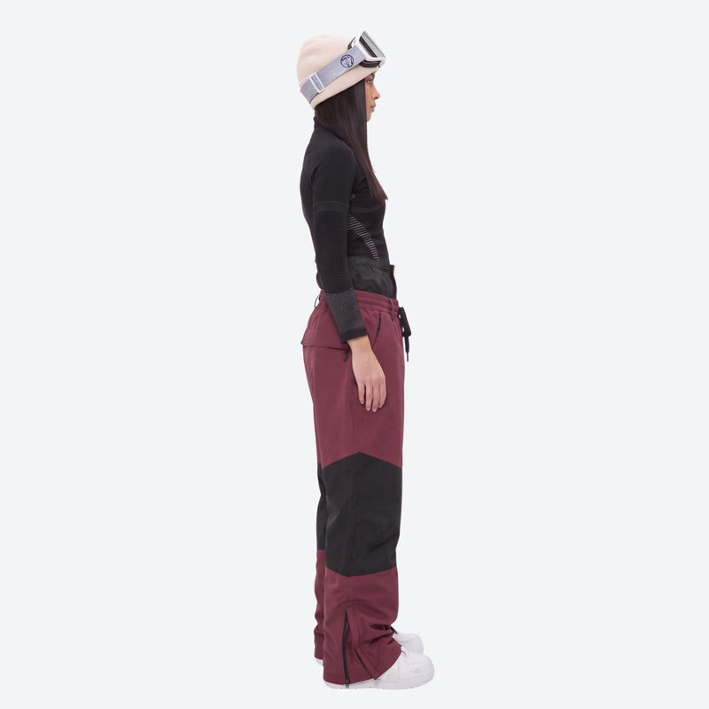 Breathable ski jacket and snow pants combo - women's wine colorblock pants with black base layer, on-model side view