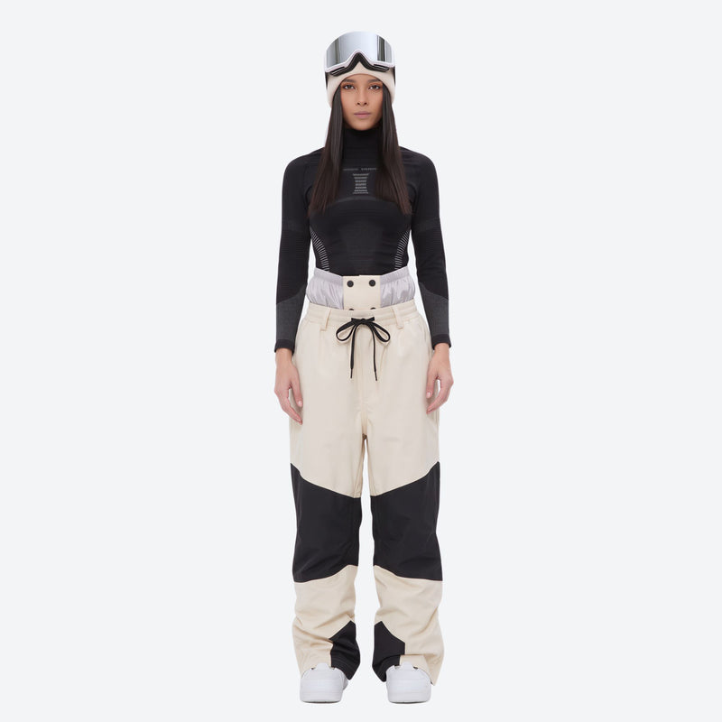 Breathable ski jacket and snow pants combo - women's cream colorblock pants with black base layer, on-model front view