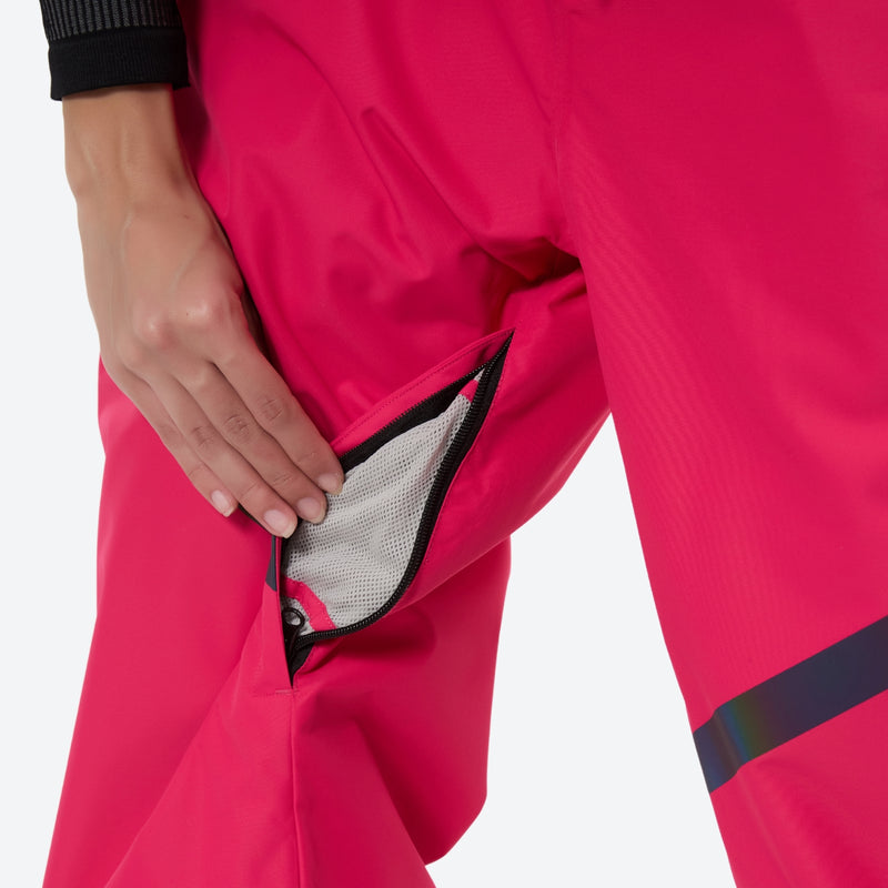 Women's snowboard jacket and wide-leg pants - pink snow pants, thigh zip vent close-up with hand, for skiing and snowboarding