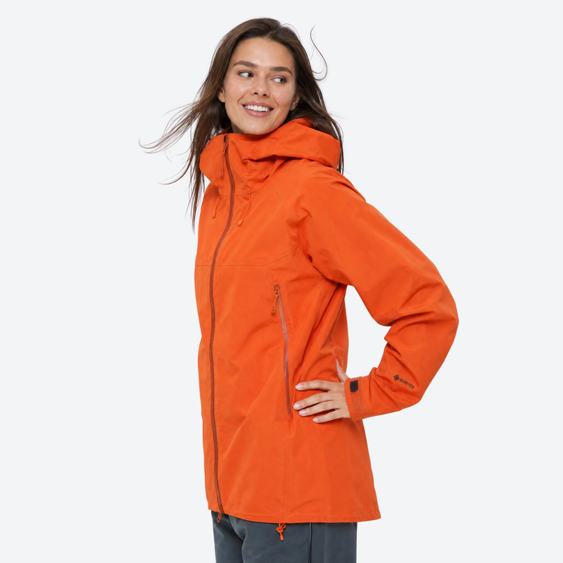 Women's waterproof 3L hardshell ski jacket - orange hardshell jacket, front view with hand on hip, for hiking and travel