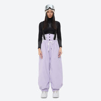 
                  
                    Women's 2-layer snowboard jacket and bibs - lavender bib pants with black top, for powder days and winter commute
                  
                