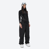 
                  
                    Unisex 2-layer snowboard jacket and pants - black snow pants with black top, on-model front view, for resort and street wear
                  
                