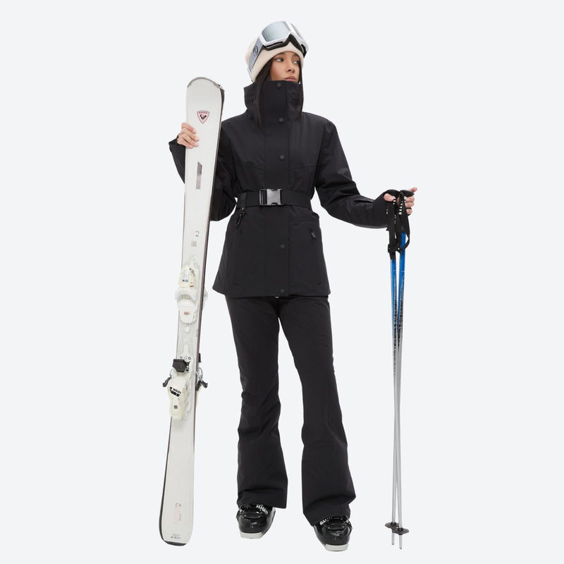 Women's belted snow jacket with suspender pants - black, front with upright skis and poles, for resort and cross-country days