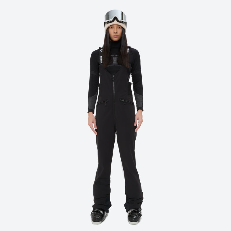 Women's fur trim hood snow jacket with suspender bibs - black bib pants, on-model front view, for snowy mountain travel