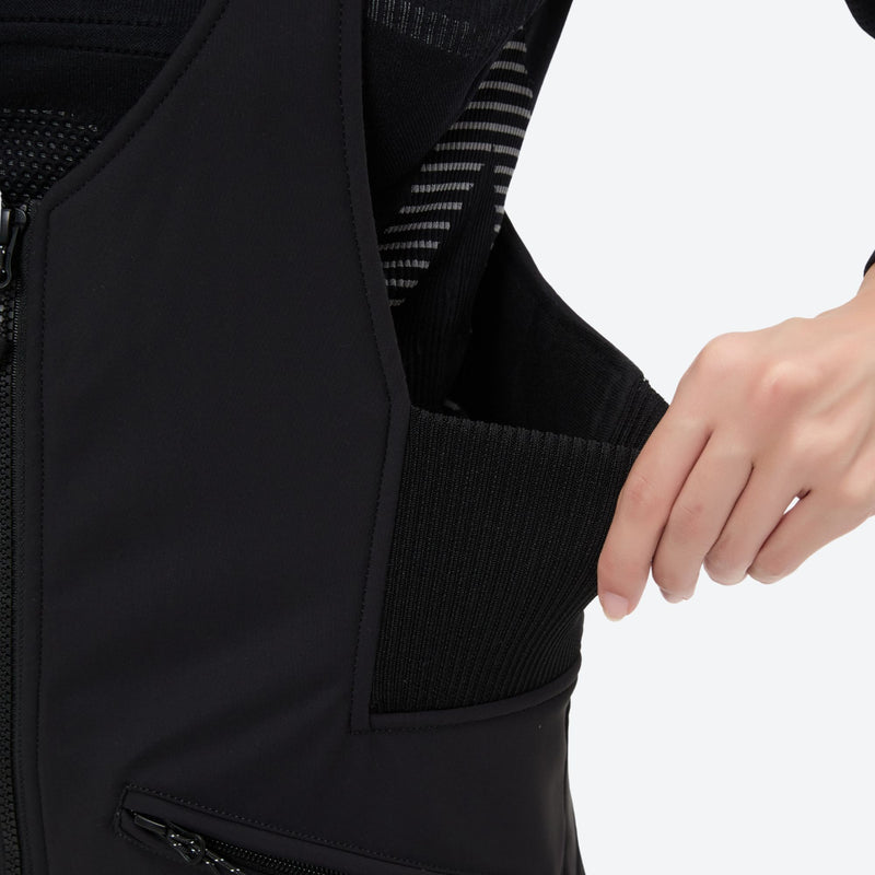 Women's 3-layer breathable ski suit set - black bib pants, waist pocket close-up with hand, for cold-weather winter sports