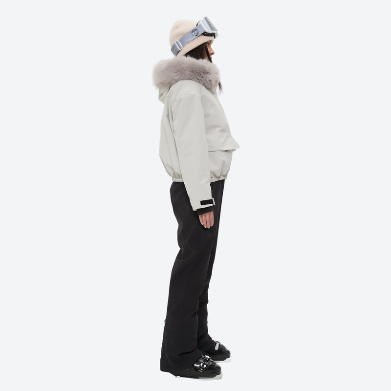 Women's fur trim hood snow jacket with suspender bibs - white fur trim hood jacket with black bib pants, on-model side view
